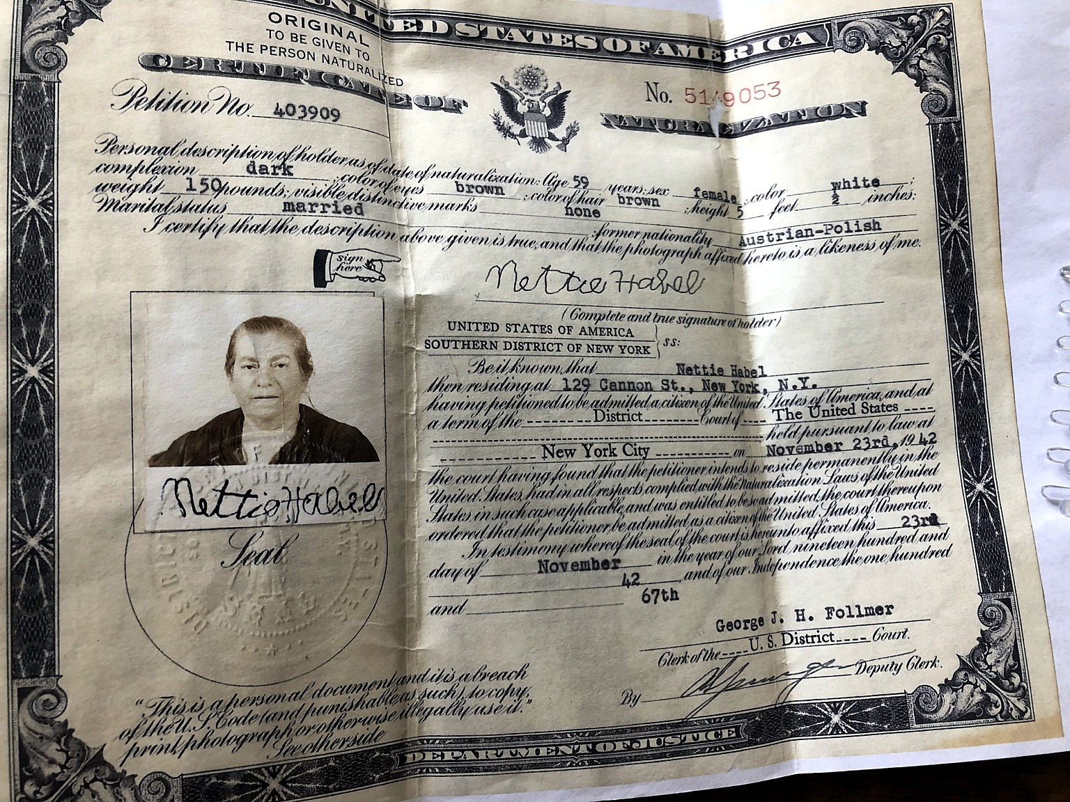 Complete certificate of naturalization for Nettie Habel, including its edges, portrait, signature, and seal